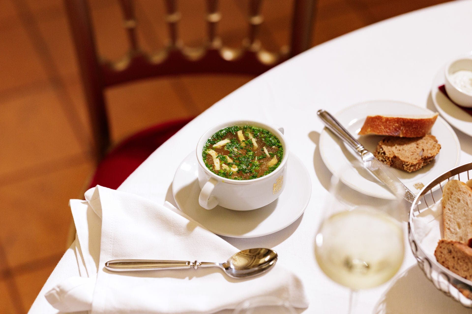Clear soup with herbs, served with bread