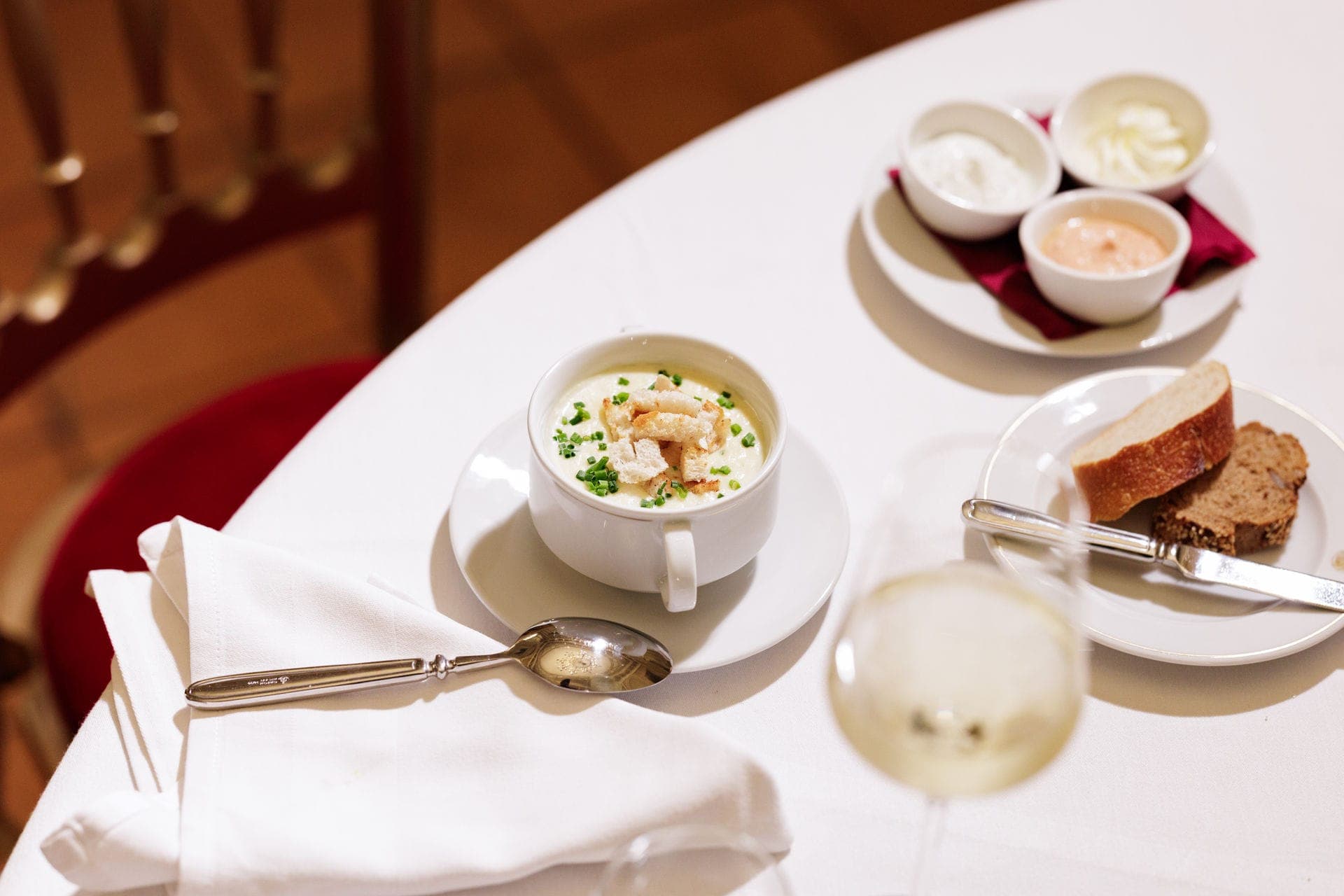 Creamy soup with herbs, bread and spreads