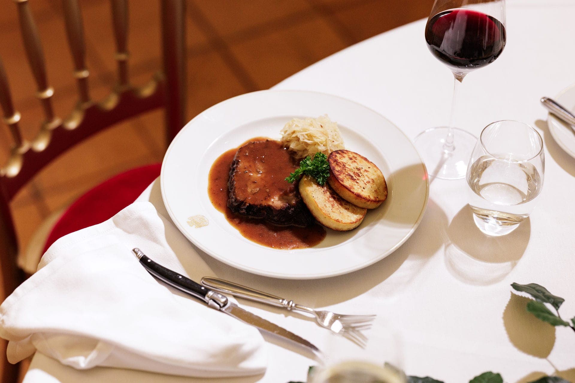Braised beef with gravy, roast potatoes and sauerkraut, with red wine