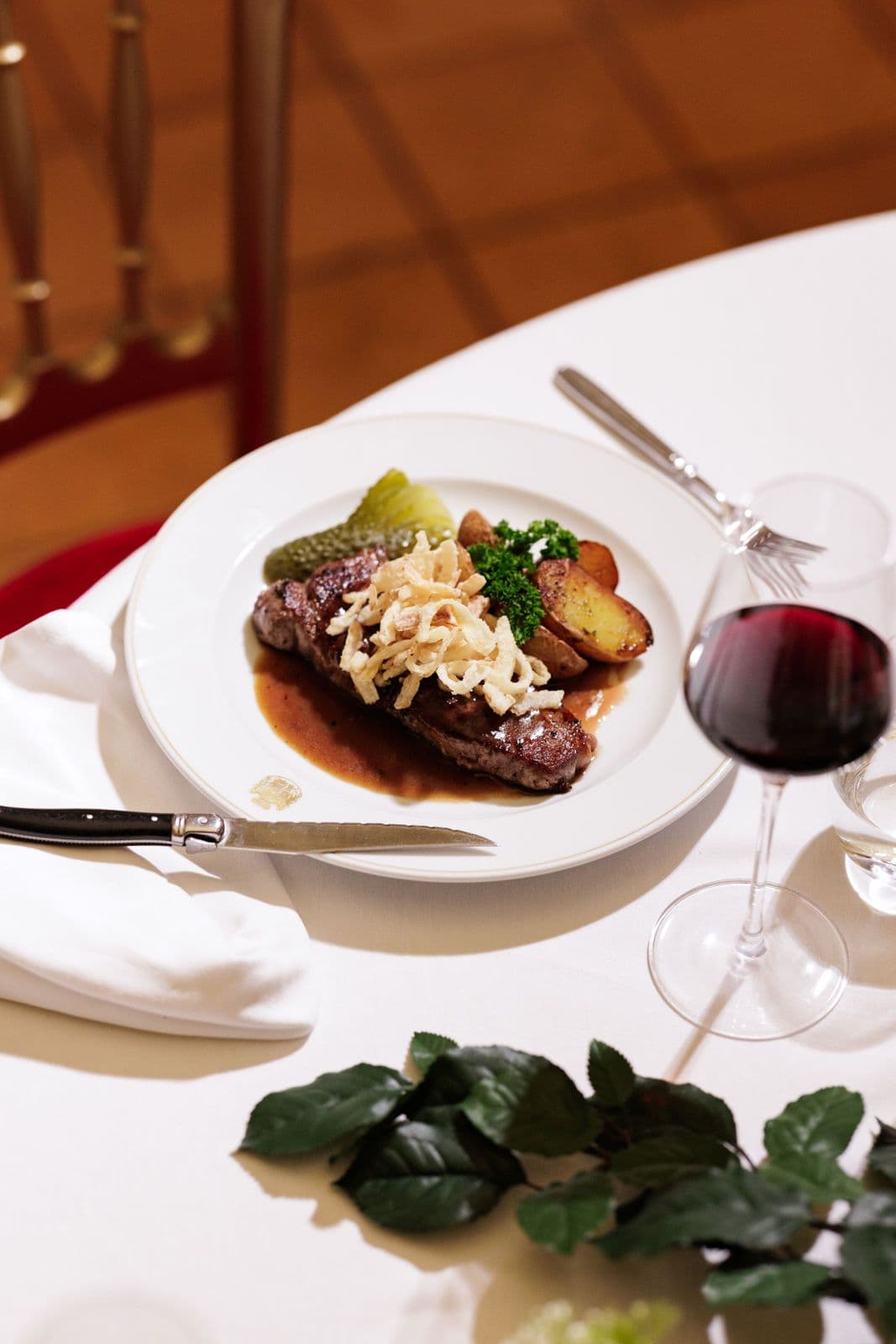 Steak with sauce, crispy onions and potatoes, with red wine