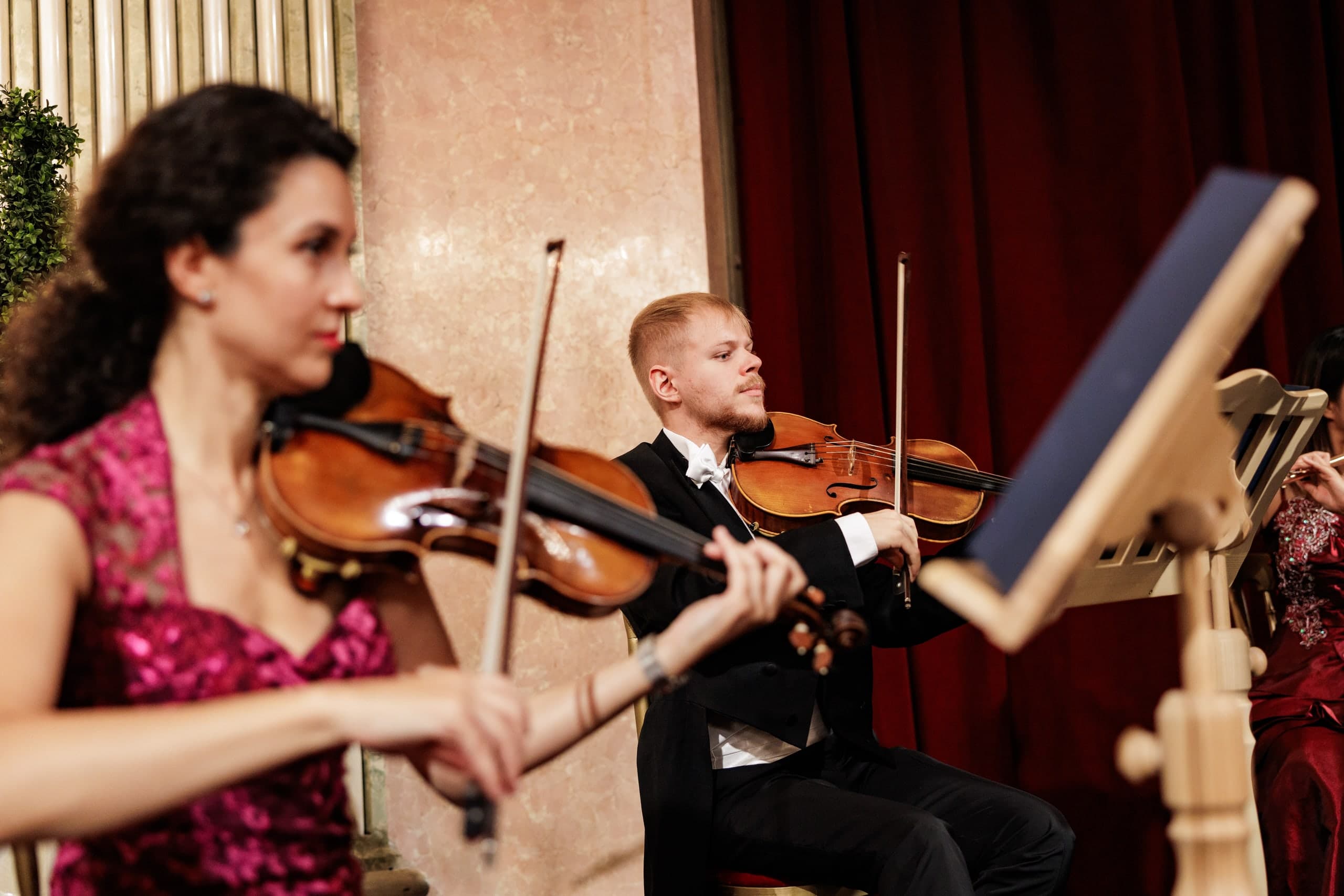 Violinists of the orchestra playing on stage