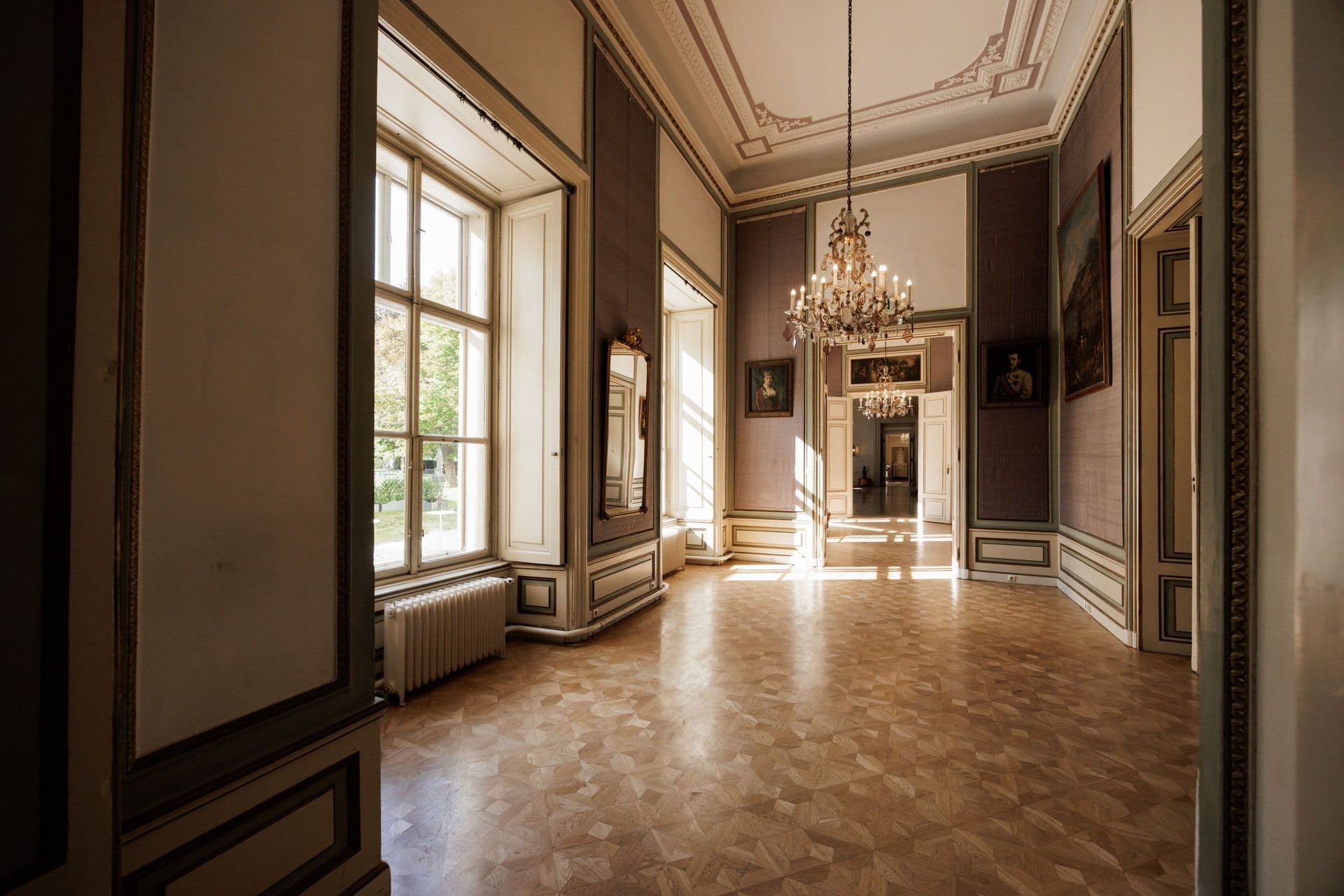 Bright suite of salons with parquet floor and chandelier