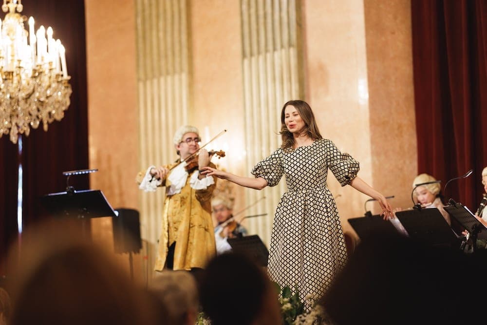 Singer in a polka-dot dress performs beside a violinist in costume
