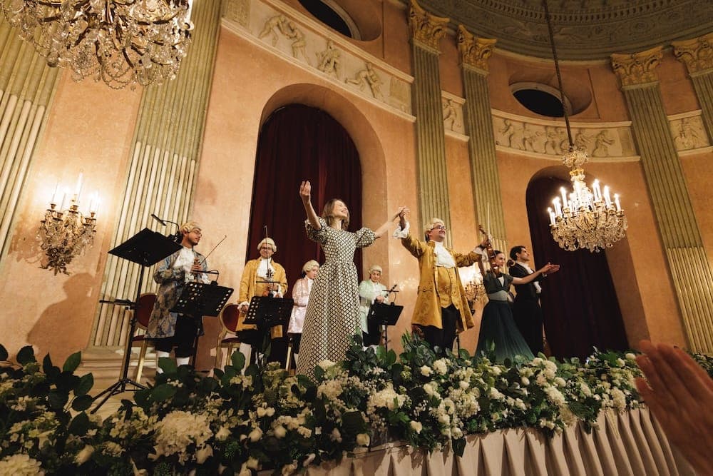 Singers and orchestra take a bow on the flower-lined stage